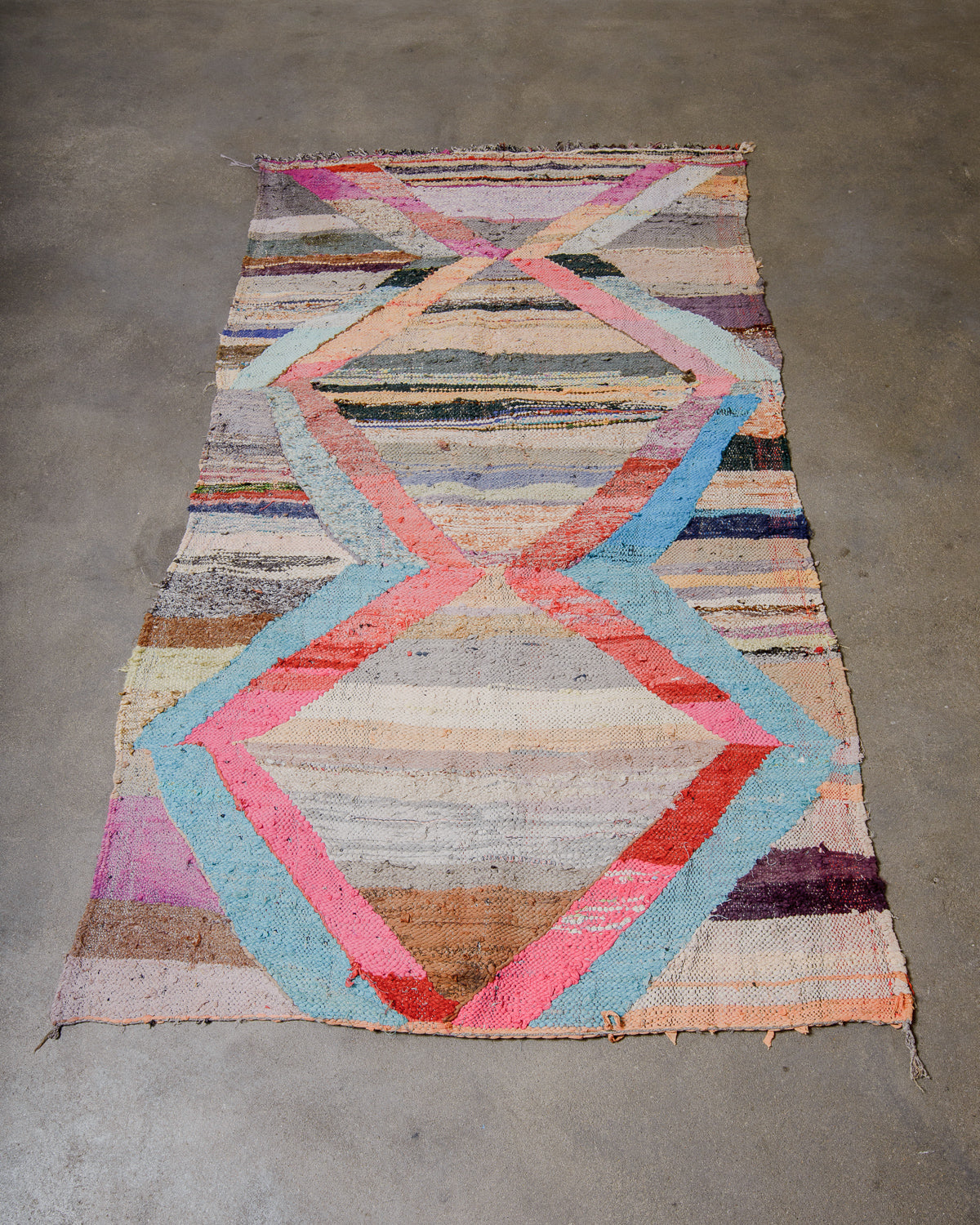 Multicolored geometric patterned rug on a concrete floor